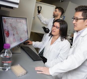 Photo of Lena Gamboa, seated, Gabe Kwong, foreground, and Ali Zamat looking at microscopic cells closeup on a computer screen
