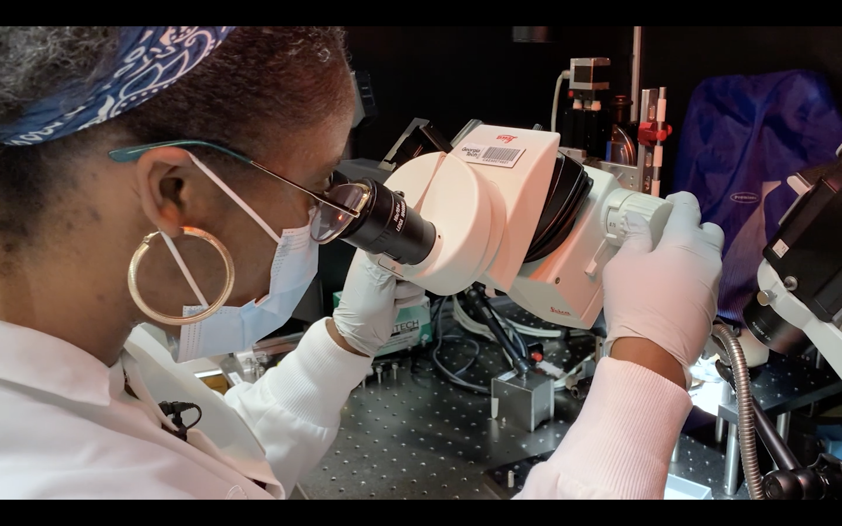 Ph.D. student Elaida Dimwamwa looks in a microscope in her lab.
