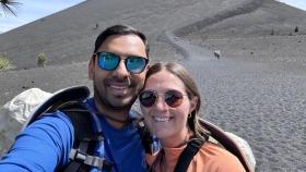 Photo of couple Tushar (on the left) and his wife Mattie (on the right) standing in front of a sand dune