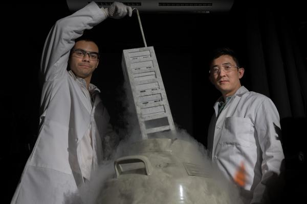 Georgia Tech and Coulter Department researcher Gabe Kwong (r.) next to a liquid nitrogen storage vat in his lab. Credit: Georgia Tech / Allison Carter