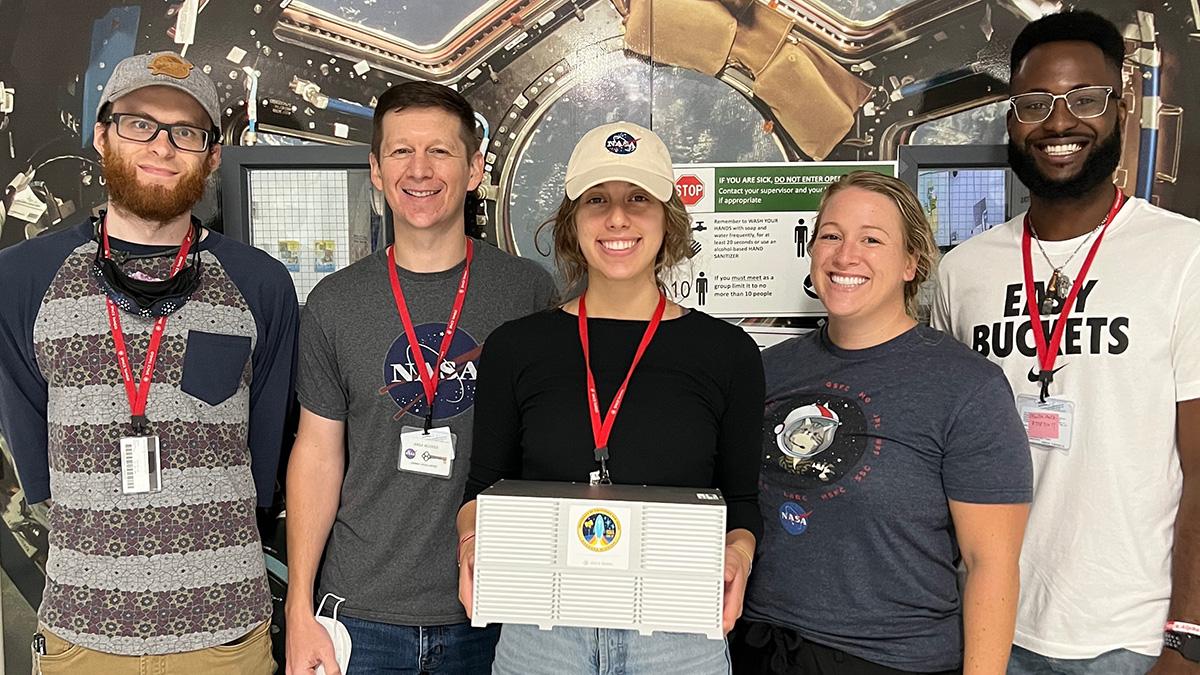 Fourth-year student Nicole Frey, center, with her team and the CubeLab platform she helped develop for research on brain organoids aboard the International Space Station. The team from Space Tango and the University of California, San Diego included, from left, Lab Manager Drew Diddle, Software Engineering Manager Zach Jacobs, Frey, Project Manager Taylor Stallings-Pinnick, and Mechanical Engineer Malik Moville. (Photo Courtesy: Space Tango)