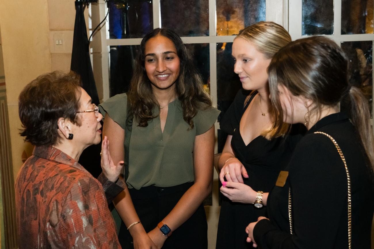 Photo of President and CEO of the Wallace H. Coulter Foundation Sue Van (left) speaking to three female biomedical engineering students positioned on the right side of the photo.