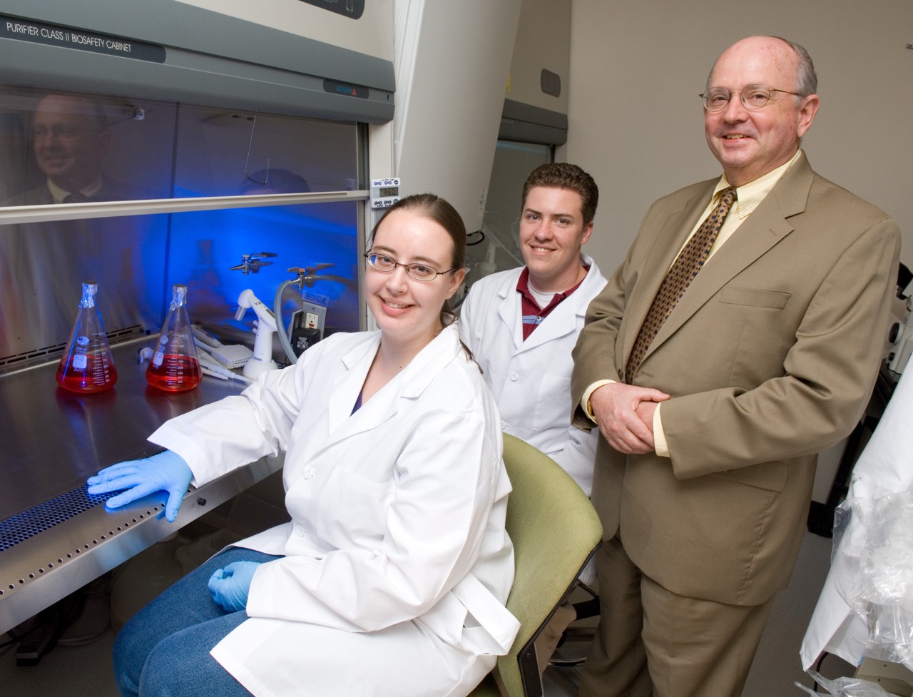 Photo of Larry McIntire and two students in his lab.