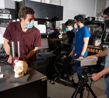 Graduate research assistants Eetu Kohtanen and Pradosh Dash and postdoctoral researchers Christopher Sugino and Bowen Jing test a human skull to measure and characterize its vibration response. (Photo: Allison Carter, Georgia Tech)