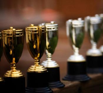 A line of gold and silver trophies. (Photo Courtesy: Brad.K via Flickr)