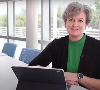 Cristi Bell-Huff sits at a conference table with her tablet computer.