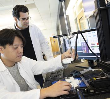  Associate Professor Costas Arvanitis and mechanical engineering Ph.D. student Hohyun "Henry" Lee with their closed-loop controlled focused ultrasound system. The system uses ultrasound-induced microbubbles to help a powerful immunotherapy target brain tumors and a custom algorithm to continuously fine tune the bubbles for maximum impact.