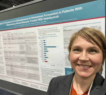 Conference attendee standing in front of a scientific research poster at a professional meeting.