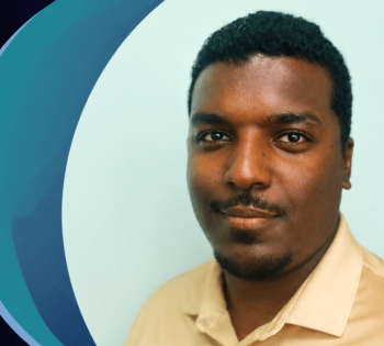 Head-and-shoulders portrait of a person wearing a light-colored collared shirt against a light background. A large blue and teal circular graphic element appears behind the person along the left side of the image. The person faces the camera.