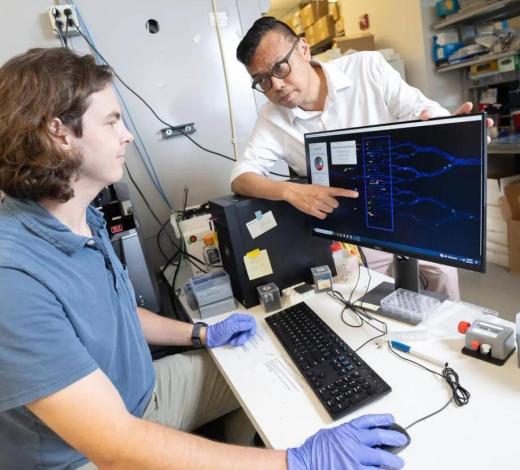 A professor showing a student something on a lab computer screen