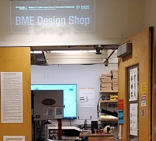 Photo of the two wood doors leading into a makerspace with an entrance sign above the door that says "BME Design Shop"