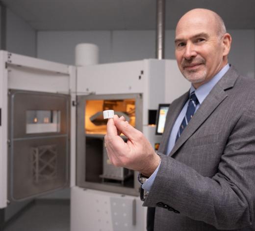 Photo of Prof. Scott Hollister holding a lifesaving 3D-printed airway splint that he created with a group of researchers
