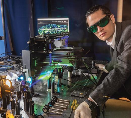 Photo of Professor Paco Robles standing in front of a machine in his lab