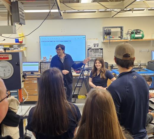 Photo of a group of prospective students and parents taking a tour of the BME Design Shop. Man speaking to the group (he is the manager of the makerspace).
