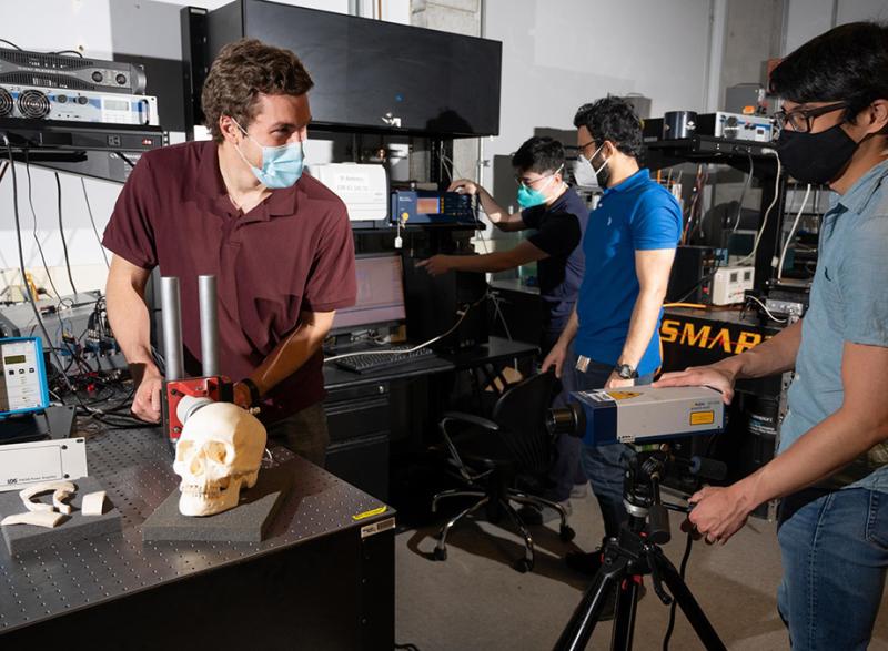 Graduate research assistants Eetu Kohtanen and Pradosh Dash and postdoctoral researchers Christopher Sugino and Bowen Jing test a human skull to measure and characterize its vibration response. (Photo: Allison Carter, Georgia Tech)