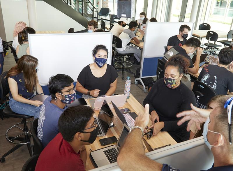 Professors of the Practice James Rains, back left, and James Stubbs talk with students about their Capstone Design projects during one of the first classes held in Coulter BME’s new Design Garden space. The collaboration and innovation space is open to biomedical engineering students 24/7 whenever classes aren’t using it. The space opened in August 2021. (Photo: Craig Bromley)