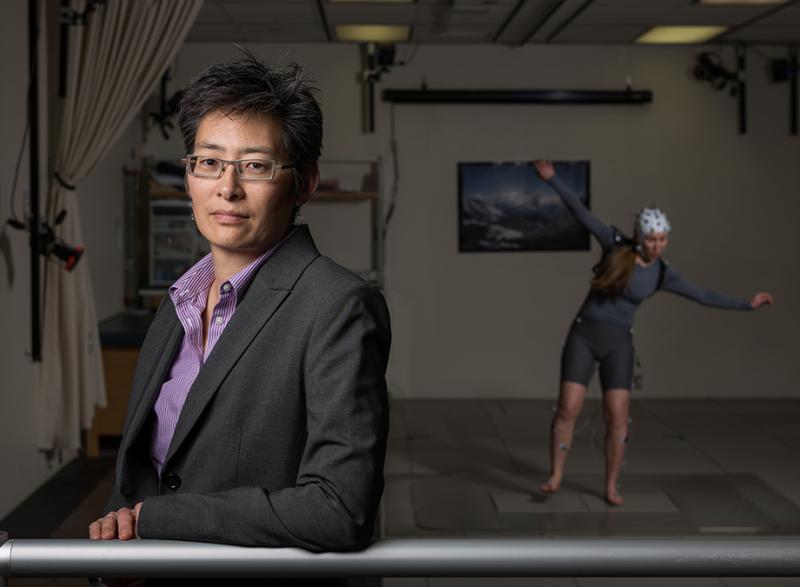 Lena Ting in her lab with a subject in the background. (Photo: Rob Felt)
