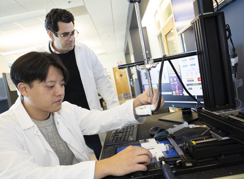 Associate Professor Costas Arvanitis and mechanical engineering Ph.D. student Hohyun "Henry" Lee with their closed-loop controlled focused ultrasound system. The system uses ultrasound-induced microbubbles to help a powerful immunotherapy target brain tumors and a custom algorithm to continuously fine tune the bubbles for maximum impact.