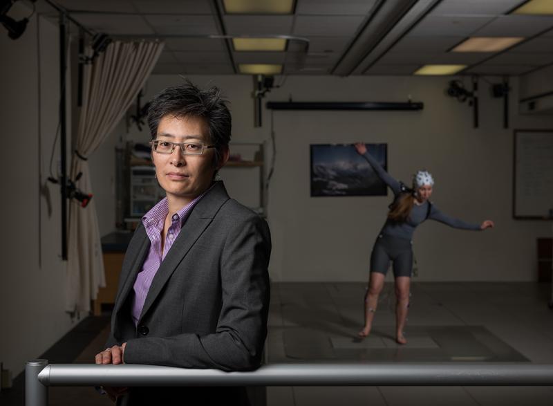 Photo of Professor Lena Ting in the foreground with a research subject in the background 