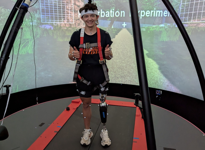 Photo of BME student Nathan Wallace testing out a special prosthetic leg