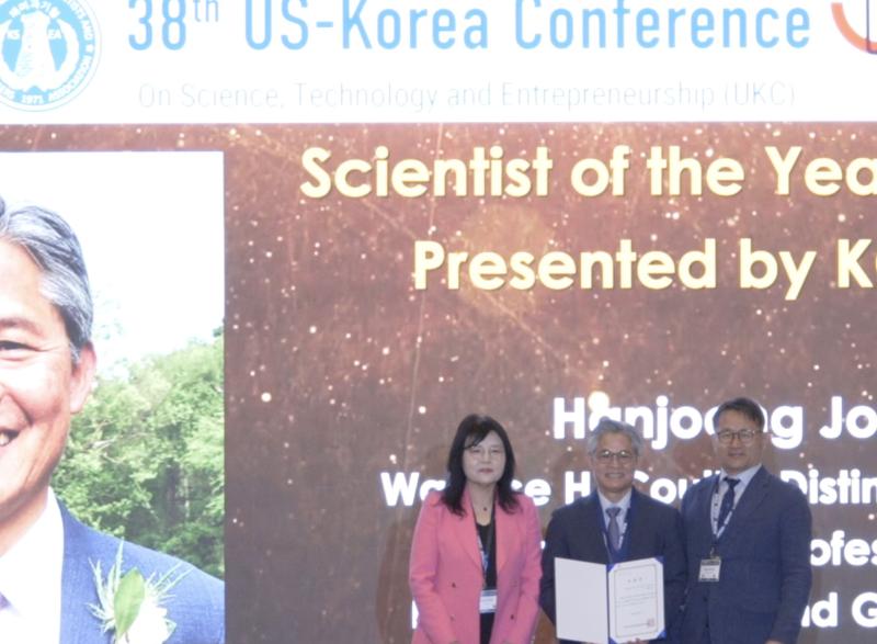 Photo of Prof. Hanjoon Jo in the center holding his Scientist of the Year award flanked by a man and woman, organizers of the ceremony
